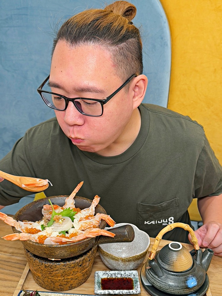 用餐者品嚐炙燒干貝鮮蝦雙拼釜飯