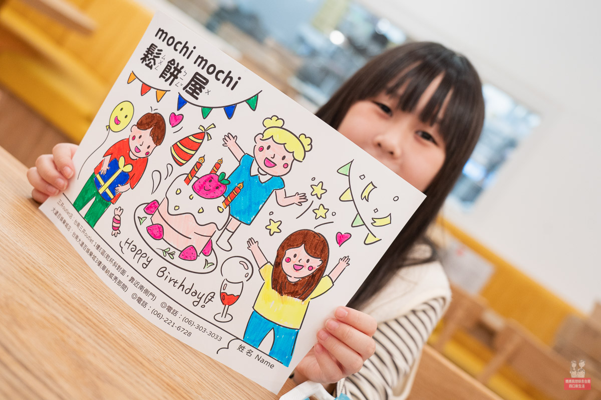 孩童展示完成著色的 Mochi Mochi 畫紙