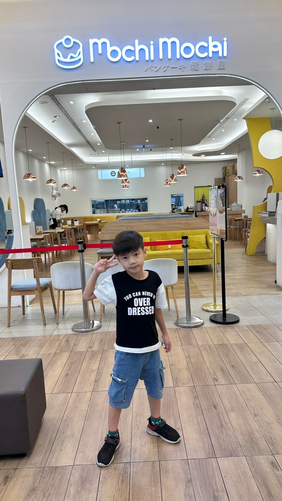 同行孩童站在 Mochi Mochi 台南三井店外留影