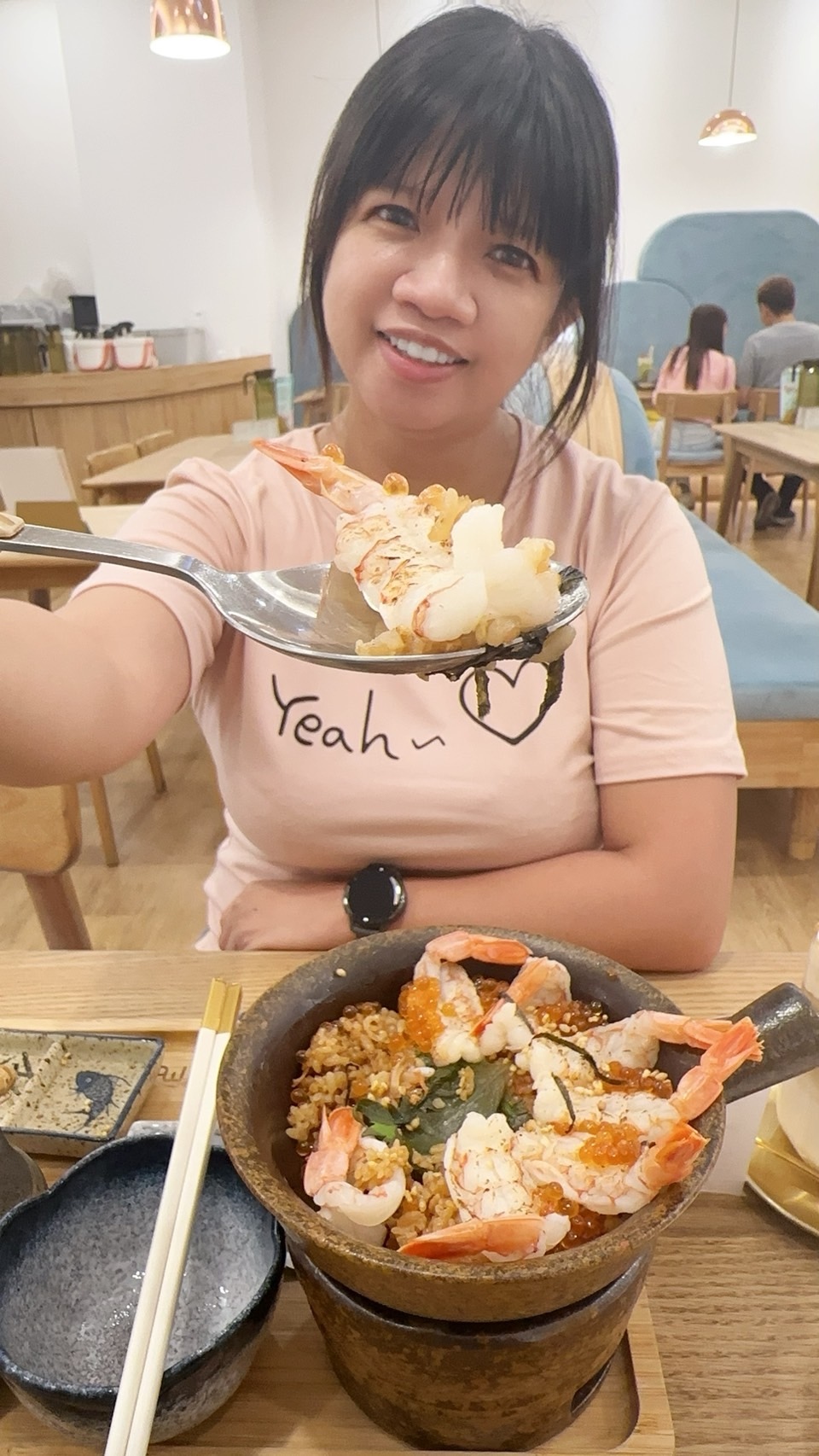 同行孩童在 Mochi Mochi 餐桌前享用海鮮釜飯