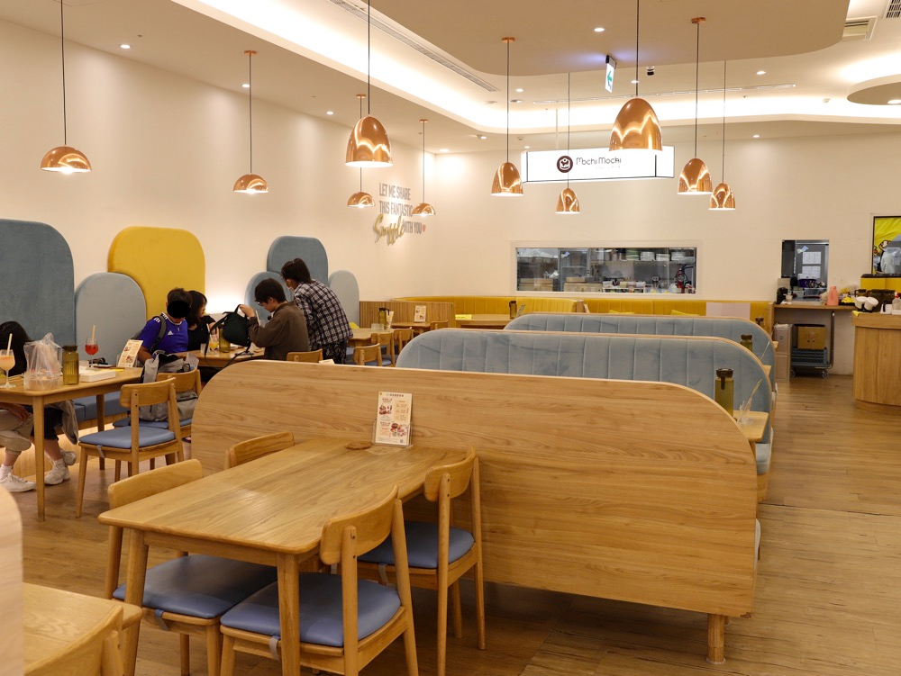 台南三井店木質餐桌與藍色卡座用餐空間