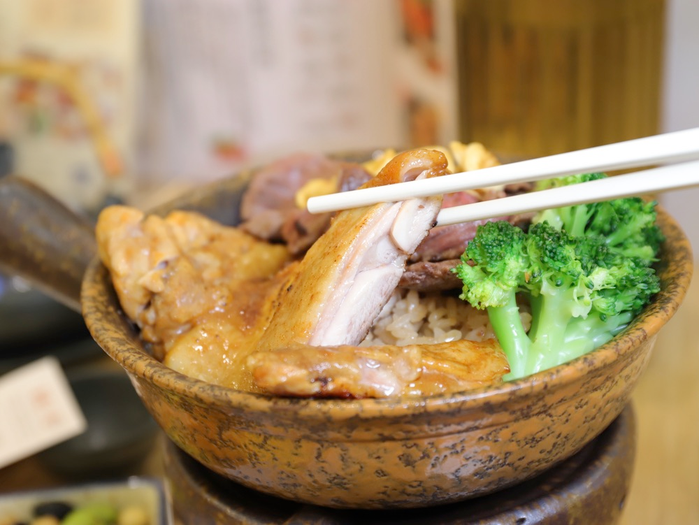 用筷子夾起釜飯中的肉片