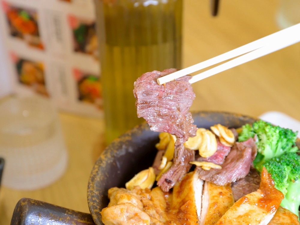 用筷子夾起釜飯中的牛肉