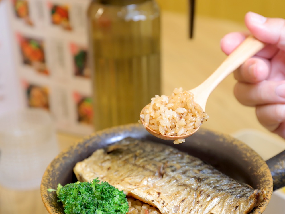 烤魚釜飯舀起米飯的近照