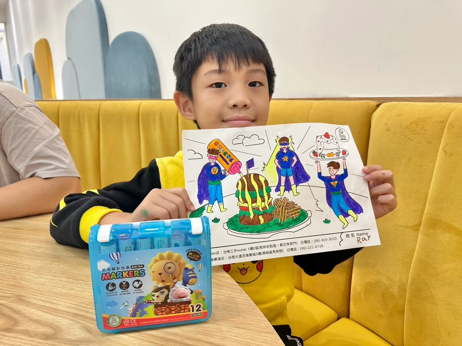 孩童展示完成的 Mochi Mochi 著色畫